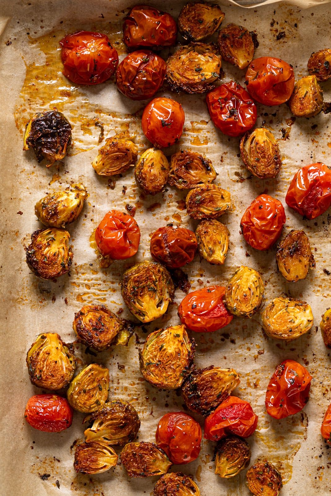 Roasted brussels sprouts and tomatoes on parchment paper