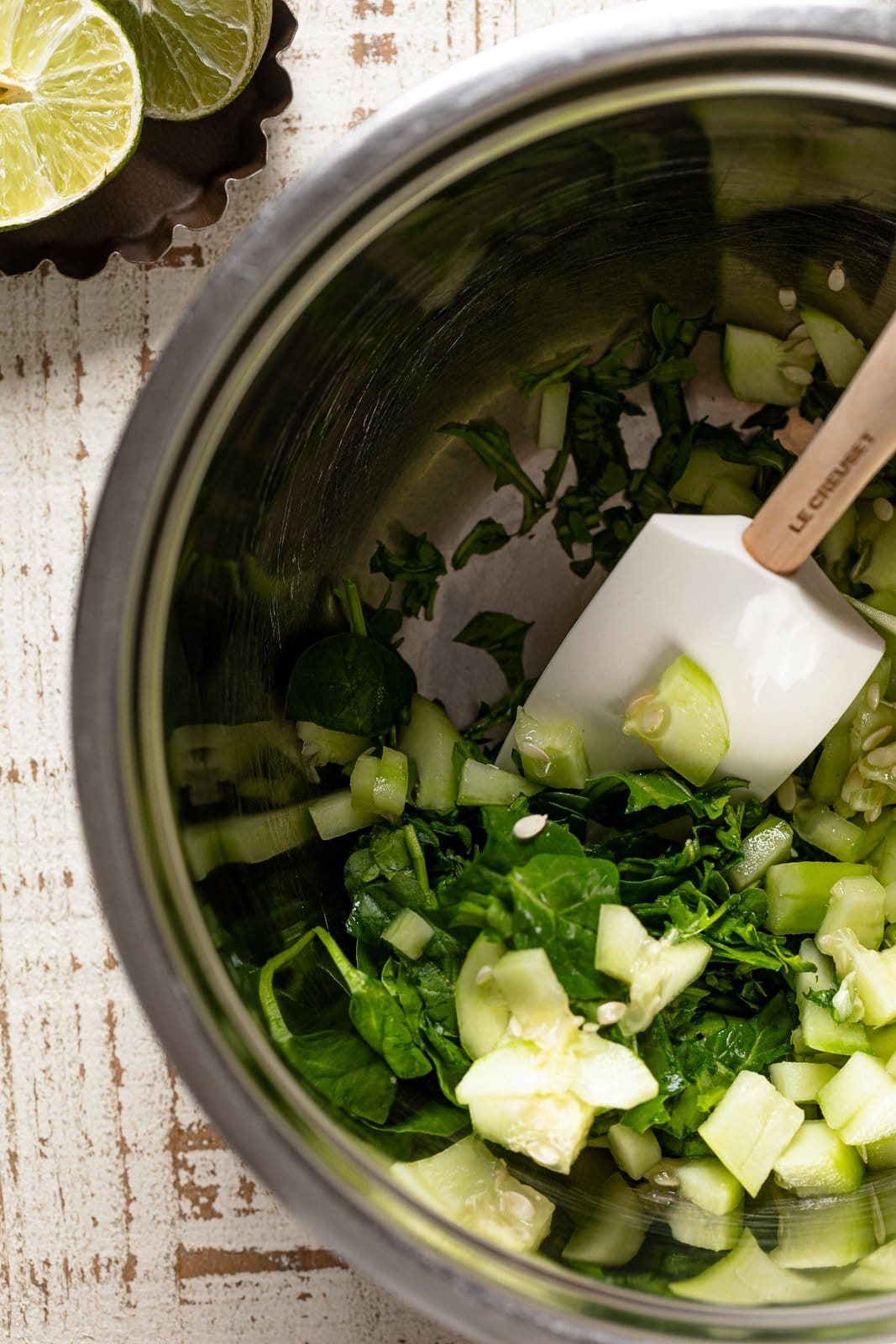 Chopped green produce being stirred in a bowl