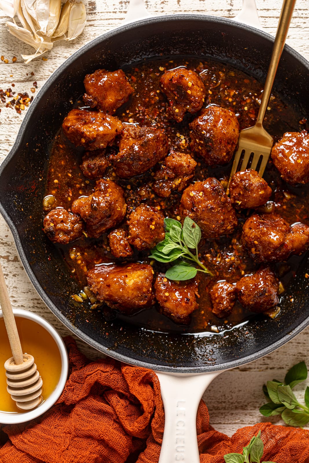 Fork stabbing a Southern Hot Honey Cauliflower Bite from a skillet