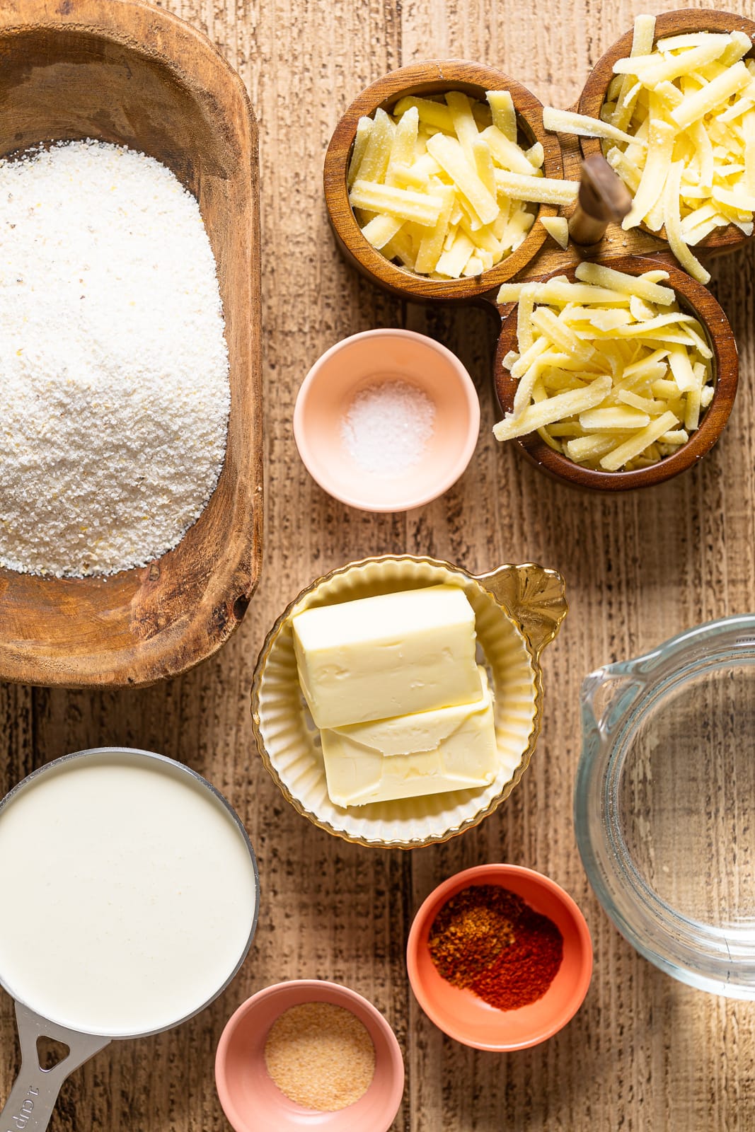 Ingredients for Creamy Southern Cheese Grits including butter, cheddar cheese, and white corn grits