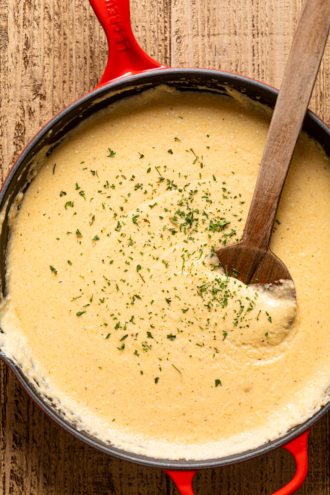 Closeup of a wooden spoon stirring.