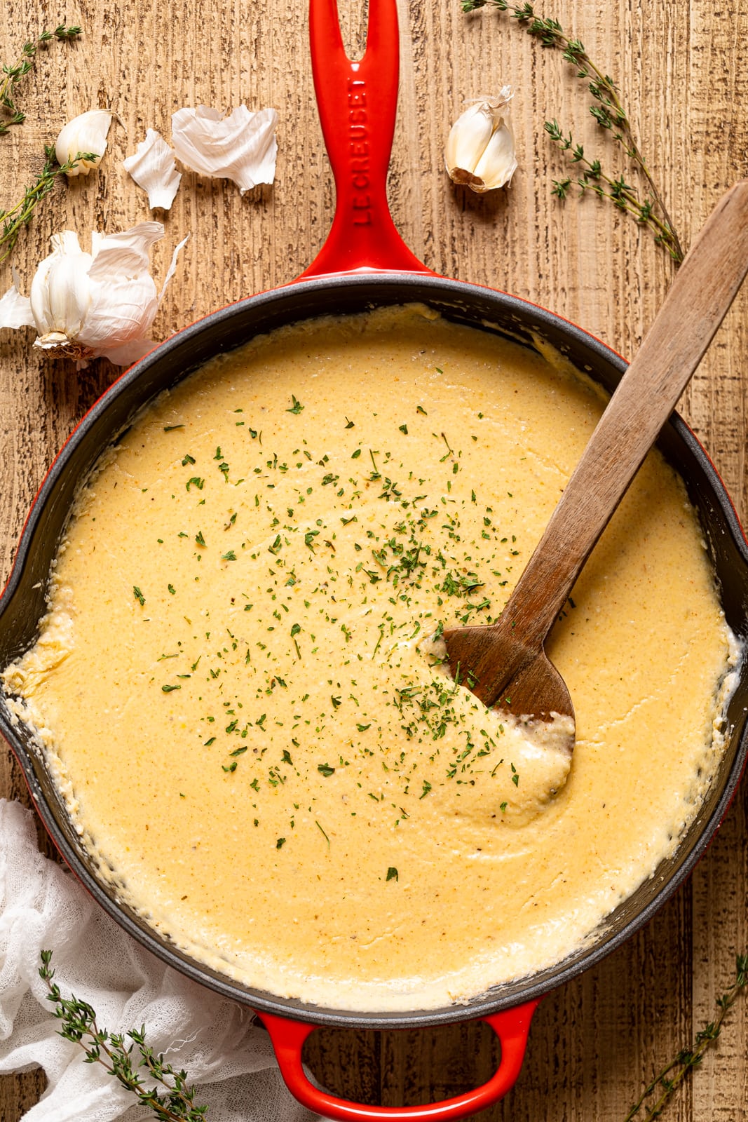 Wooden spoon stirring a pan of Creamy Southern Cheese Grits--A soul food classic