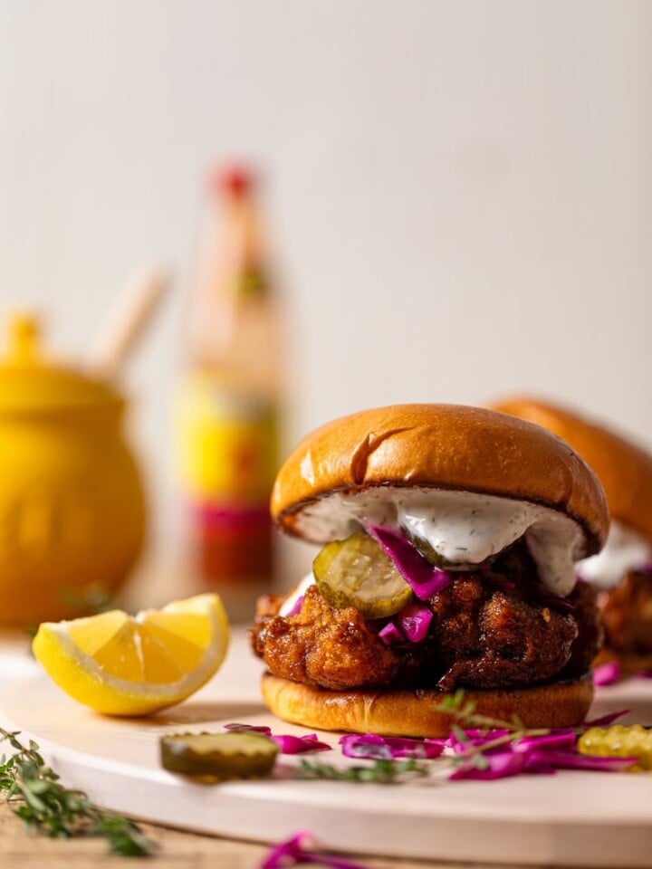 Nashville-Style Hot Cauliflower Sandwich next to a lemon wedge