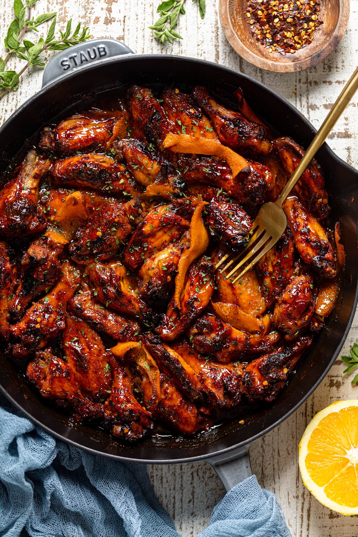 Fork in a skillet of Spicy Orange Chicken Wings