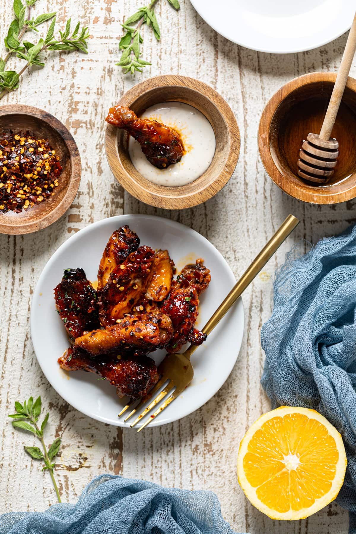 Plate of Wings next to ingredients including crushed red pepper, honey, and lemon