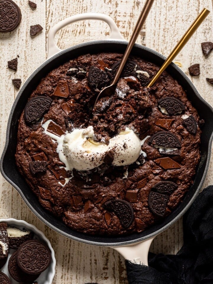 Overhead shot of spoons dipping into a Chocolate Oreo Skillet Brownie