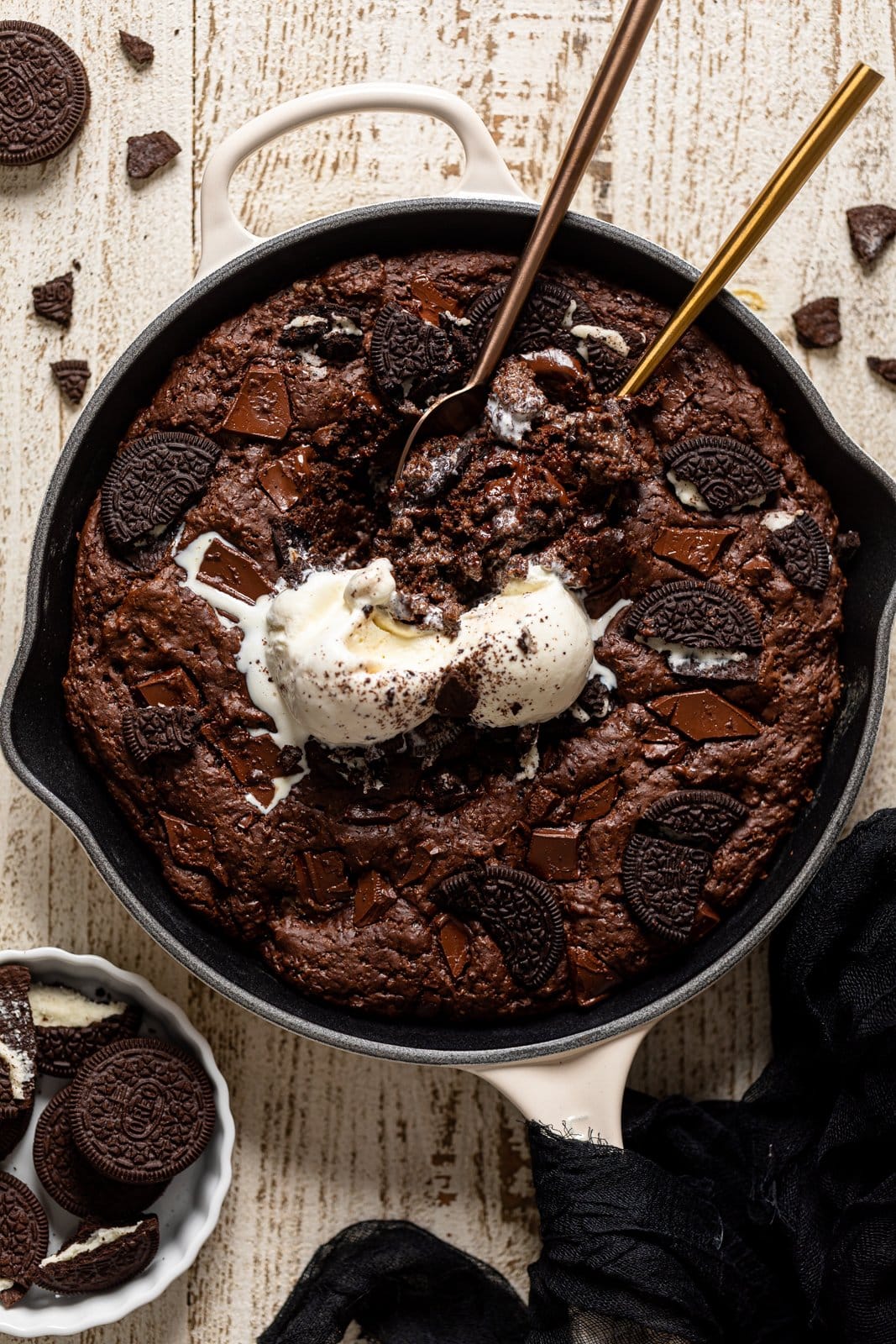 Overhead shot of spoons dipping into a Chocolate Oreo Skillet Brownie