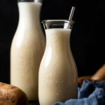 Two glass carafes of potato milk