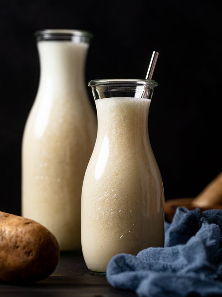 Two glass carafes of potato milk