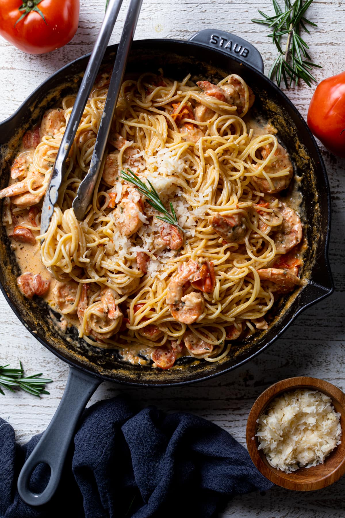 Tongs grabbing Shrimp Pasta from a skillet. The perfect weeknight dinner.