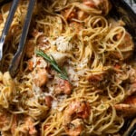 Closeup of tongs grabbing Parmesan Garlic Shrimp Scampi with Linguine