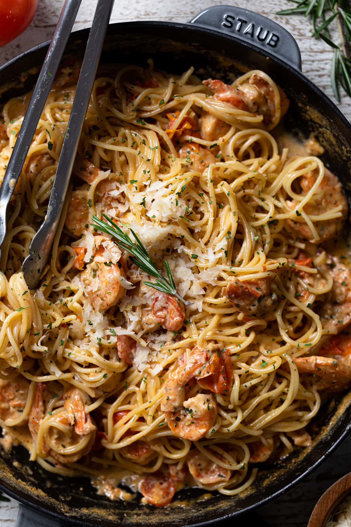 Closeup of tongs grabbing Creamy Shrimp Scampi Pasta with Linguine. The perfect weeknight dinner.