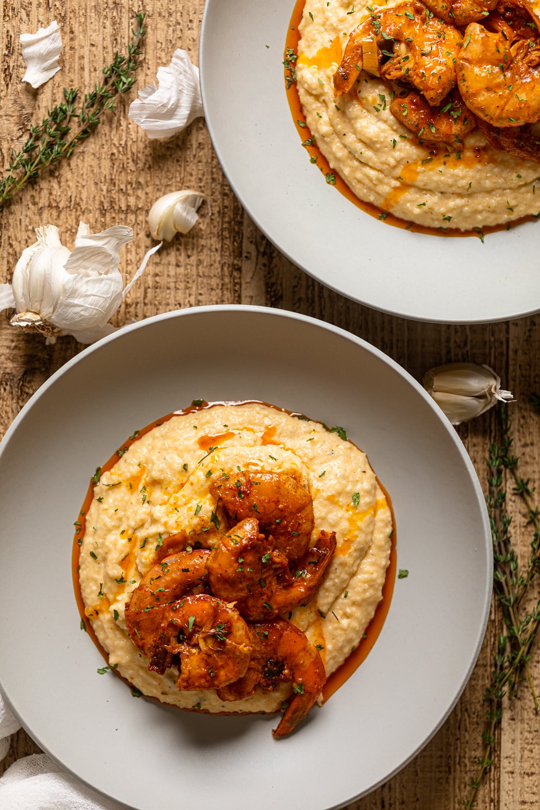 Overhead shot of two plates of Spicy Southern Shrimp and Grits