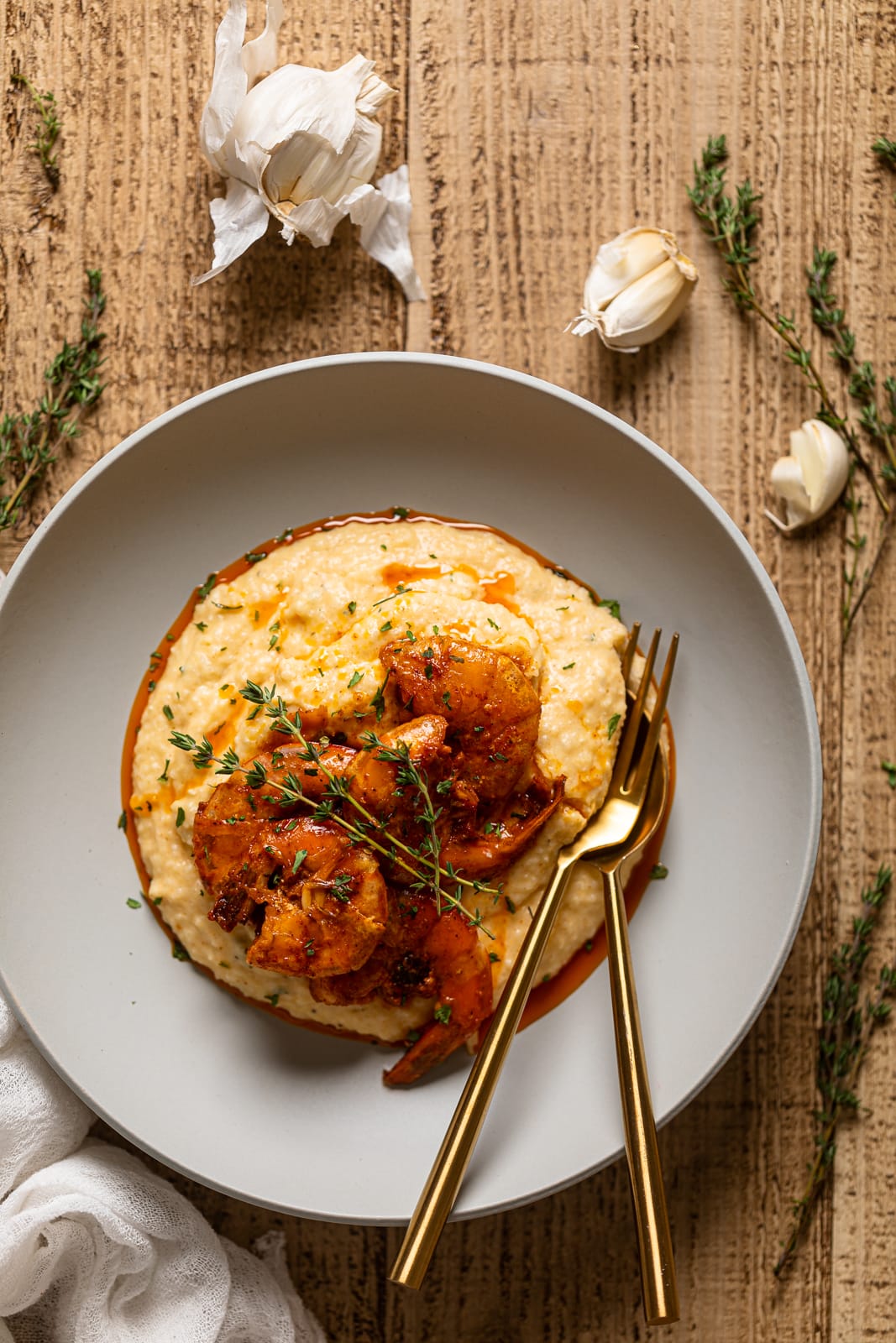 Overhead shot of a plate of Spicy Southern Shrimp and Grits with silverware