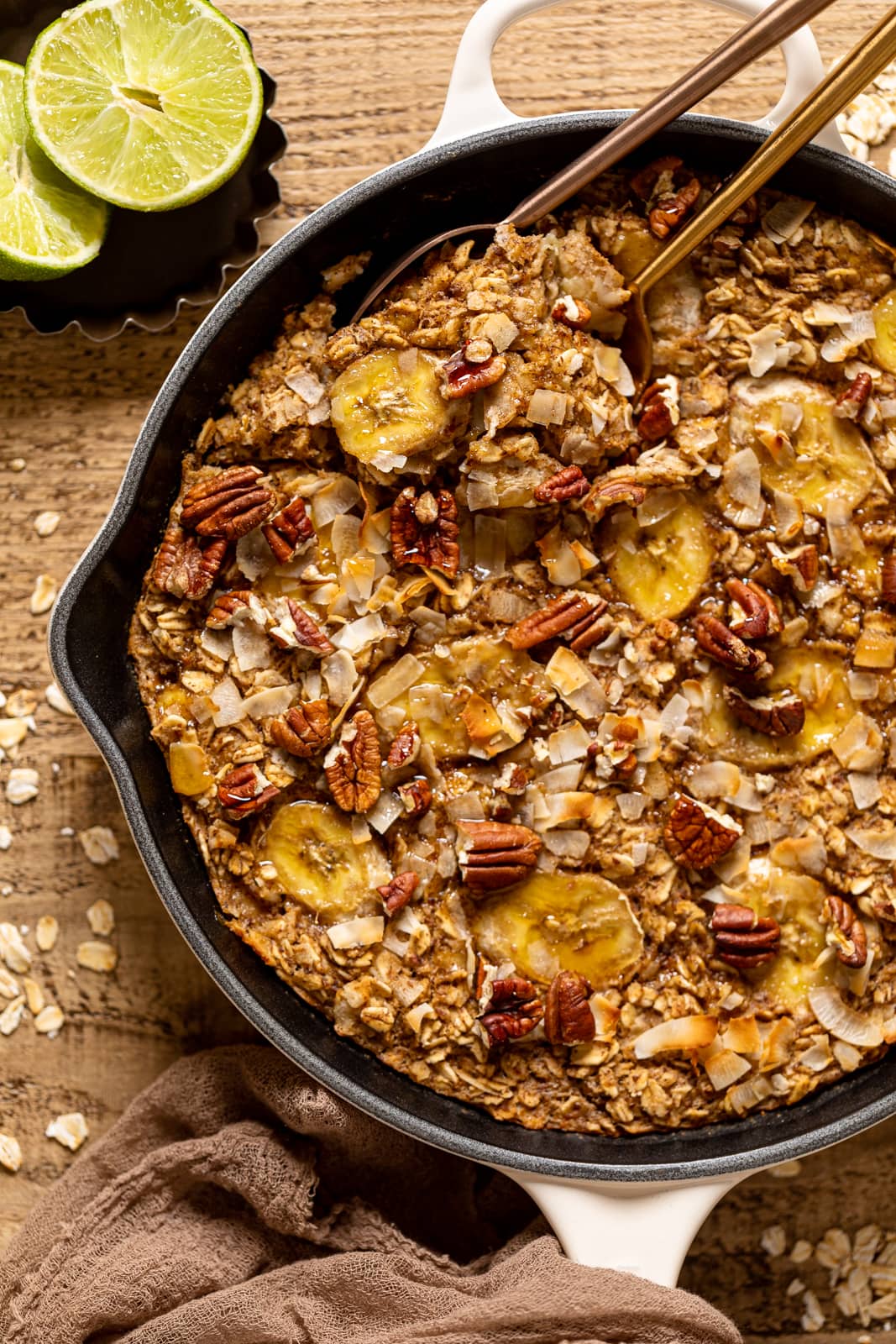 Spoons scooping Jamaican-inspired Banana Bread Baked Oatmeal out of a pan