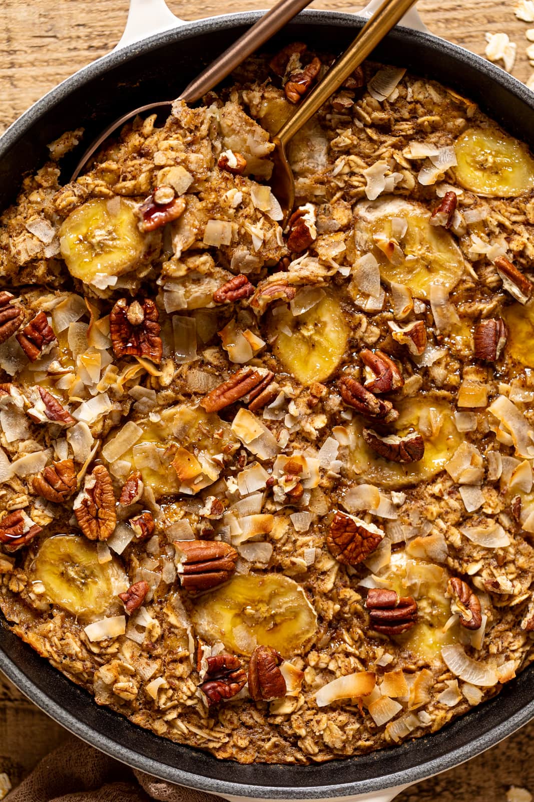 Closeup of spoons scooping Jamaican-inspired Banana Bread Baked Oatmeal out of a pan