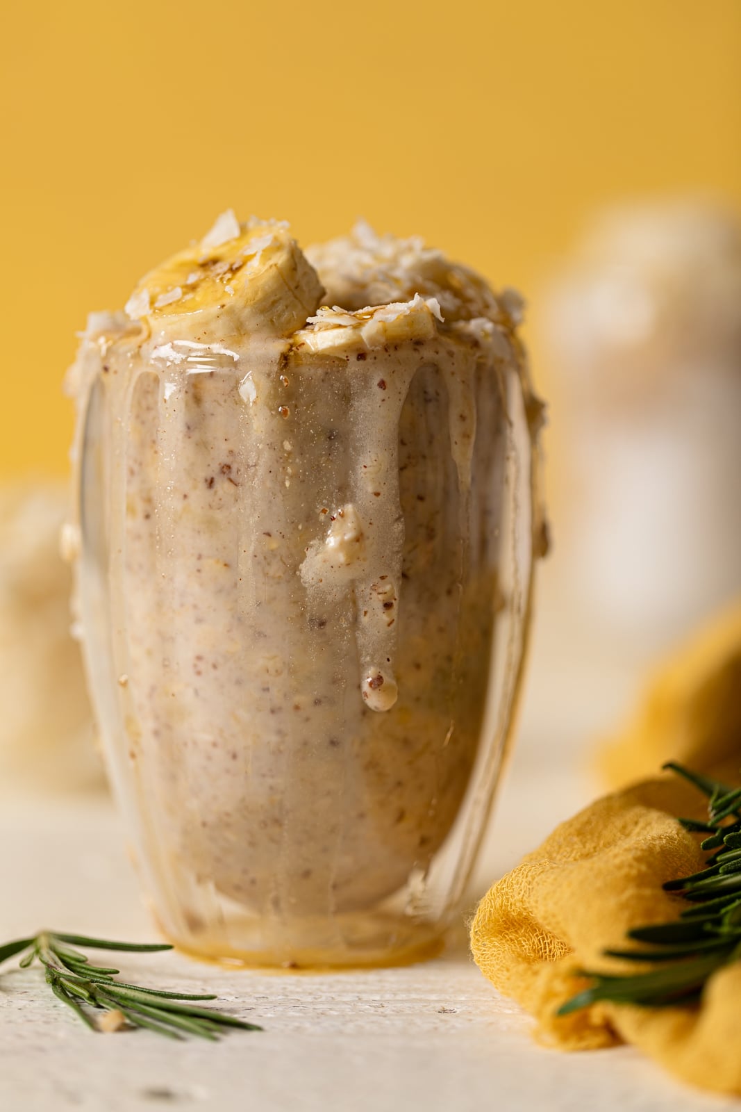 Closeup of an overflowing glass of Banana Coconut Overnight Oats