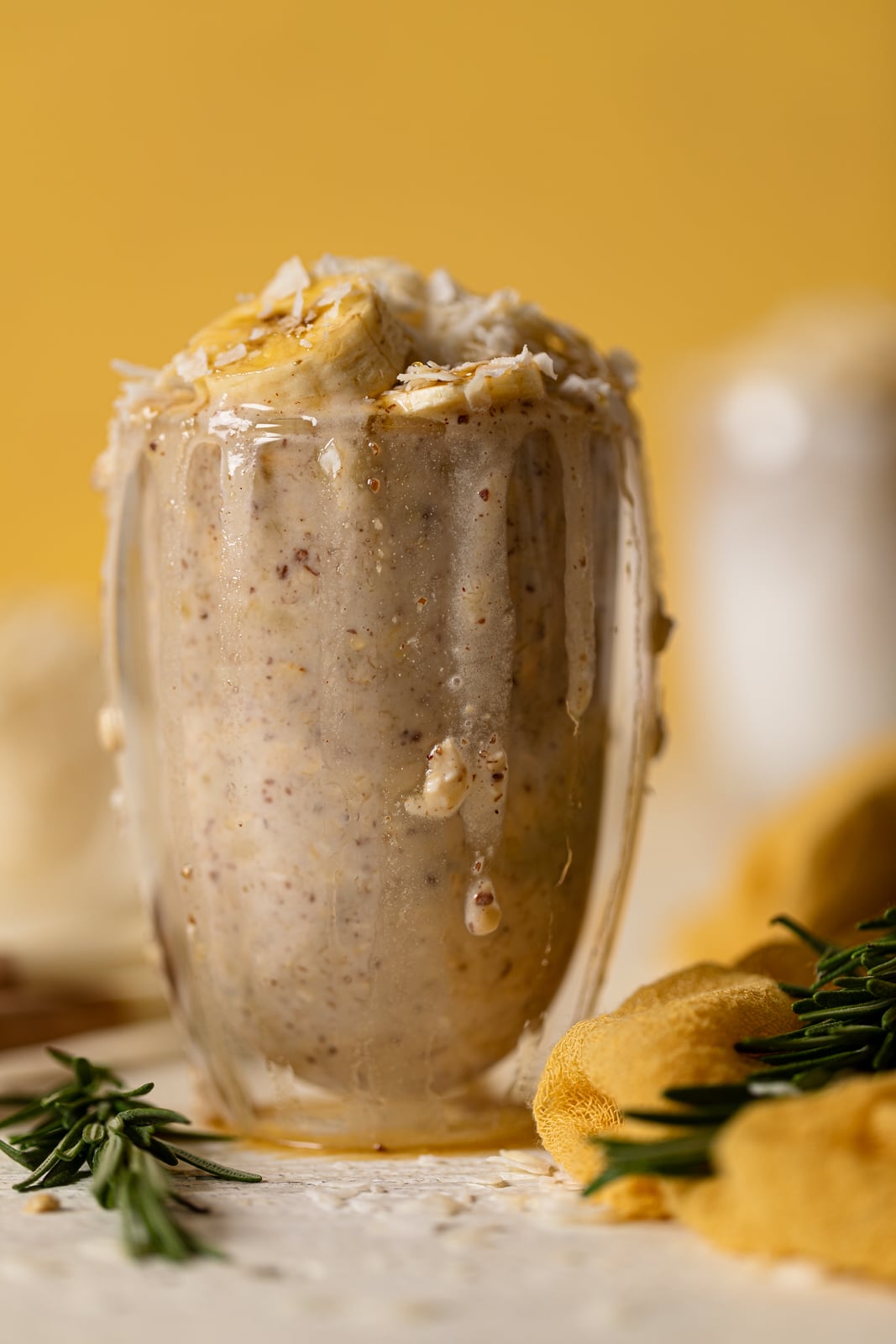 Overflowing glass of Banana Coconut Overnight Oats