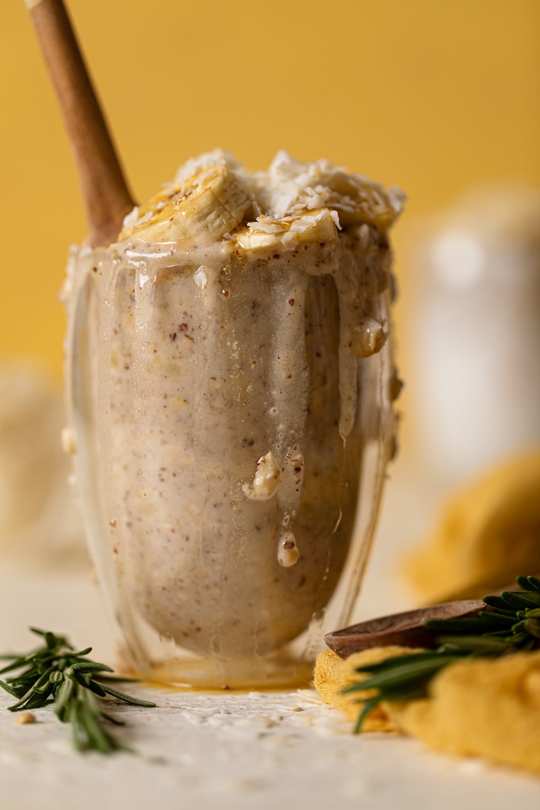 Closeup of an overflowing glass of Banana Coconut Overnight Oats