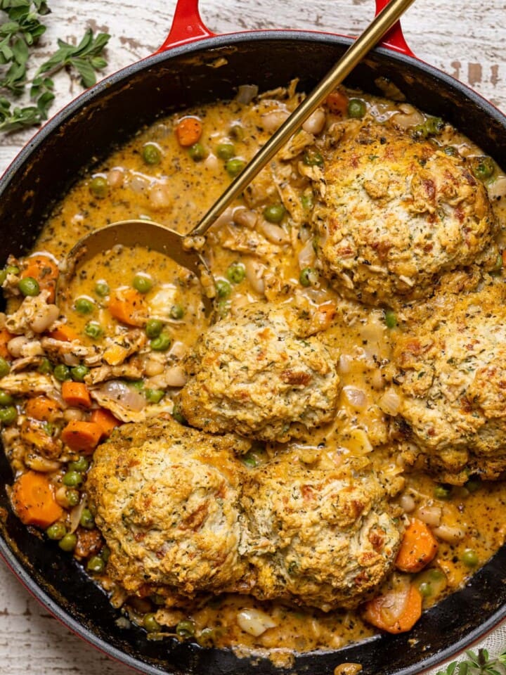 Spoon stirring a skillet of Chicken Pot Pie with Cheddar Herb Biscuits