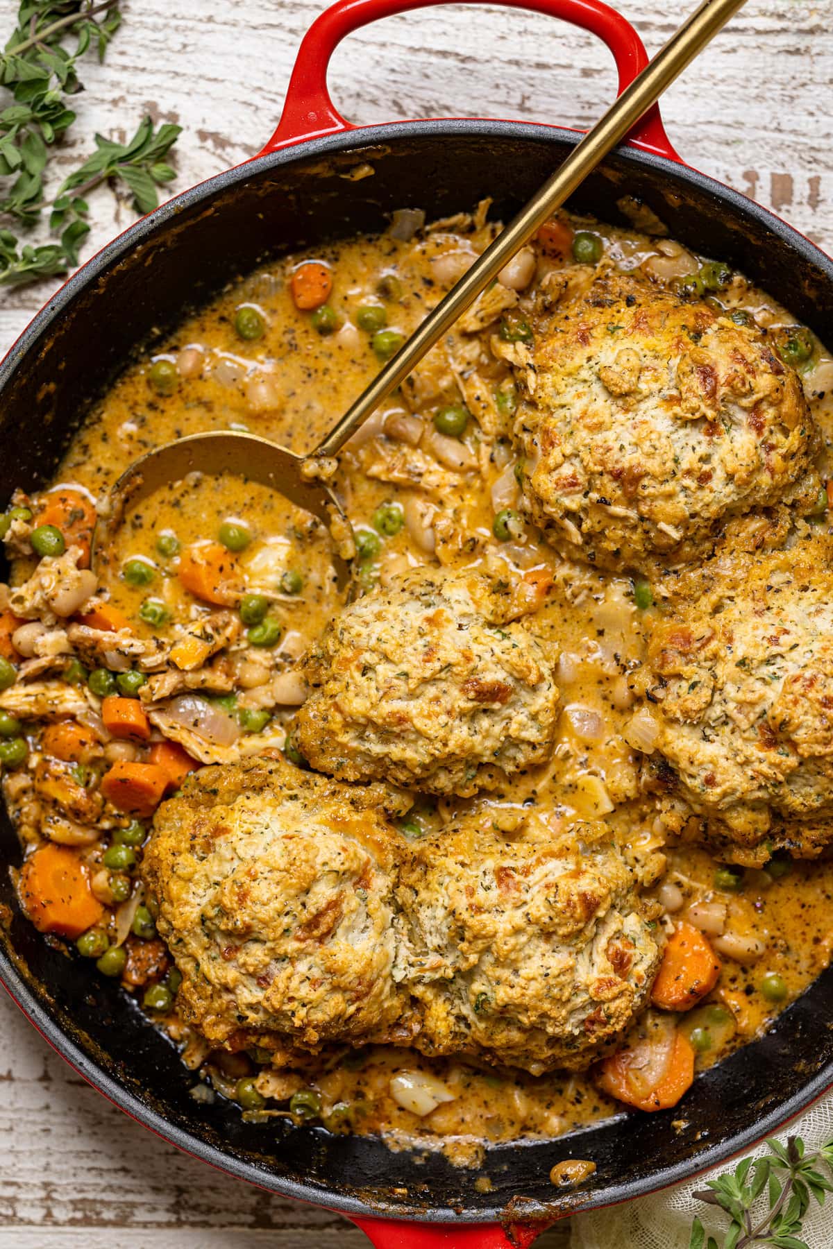 Spoon stirring a skillet of Chicken Pot Pie with Cheddar Herb Biscuits