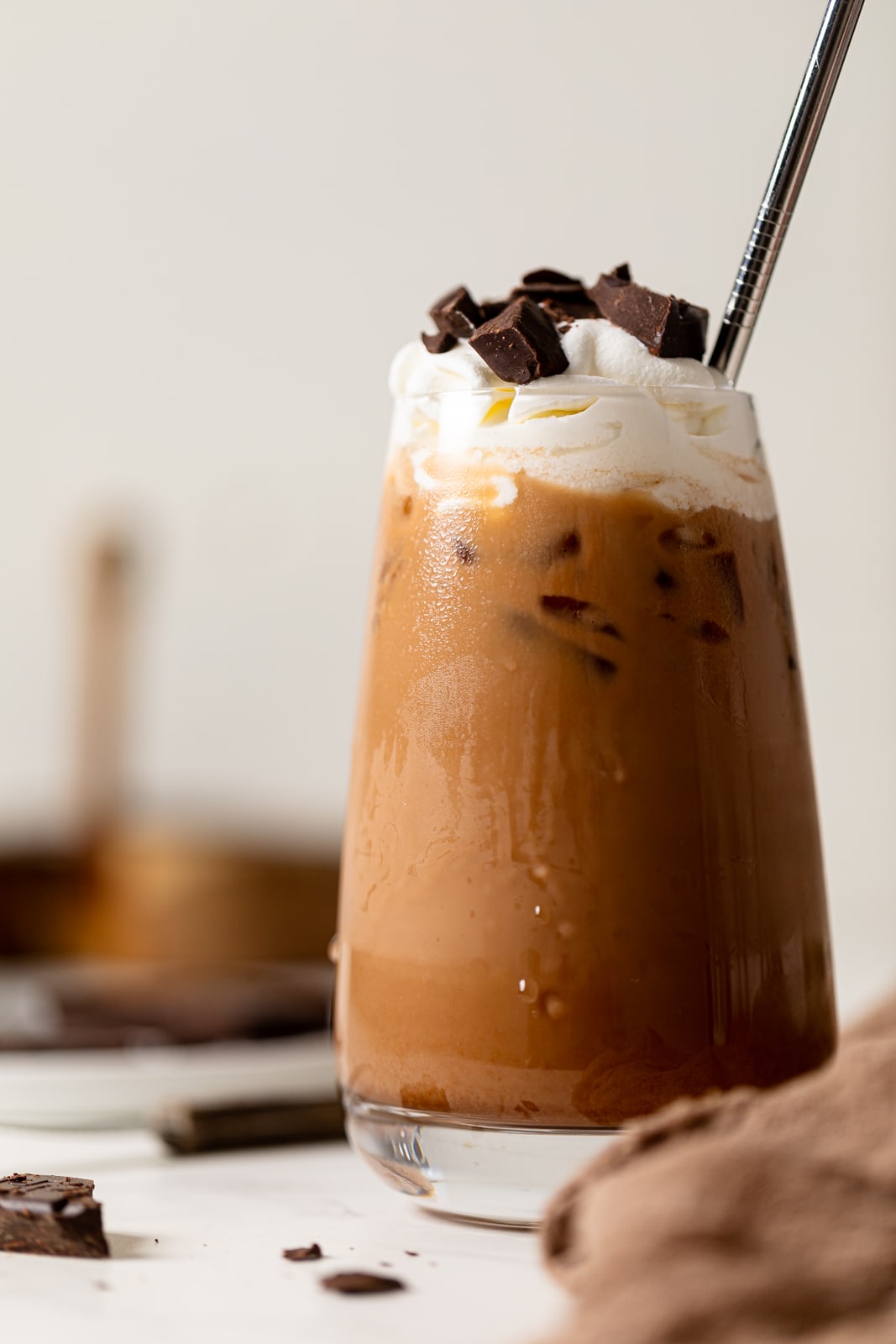 Dairy-free Iced Mocha Latte topped with coconut whipped cream and chopped chocolate