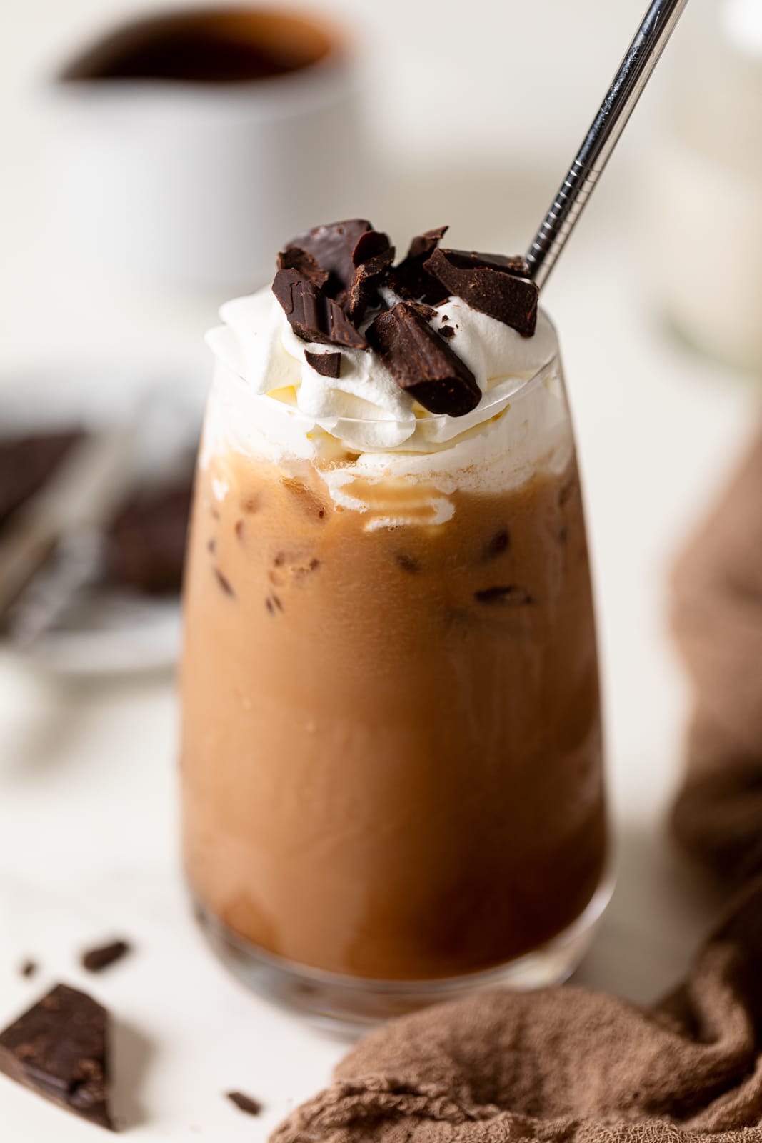 Dairy-free Iced Mocha Latte topped with coconut whipped cream and chopped chocolate