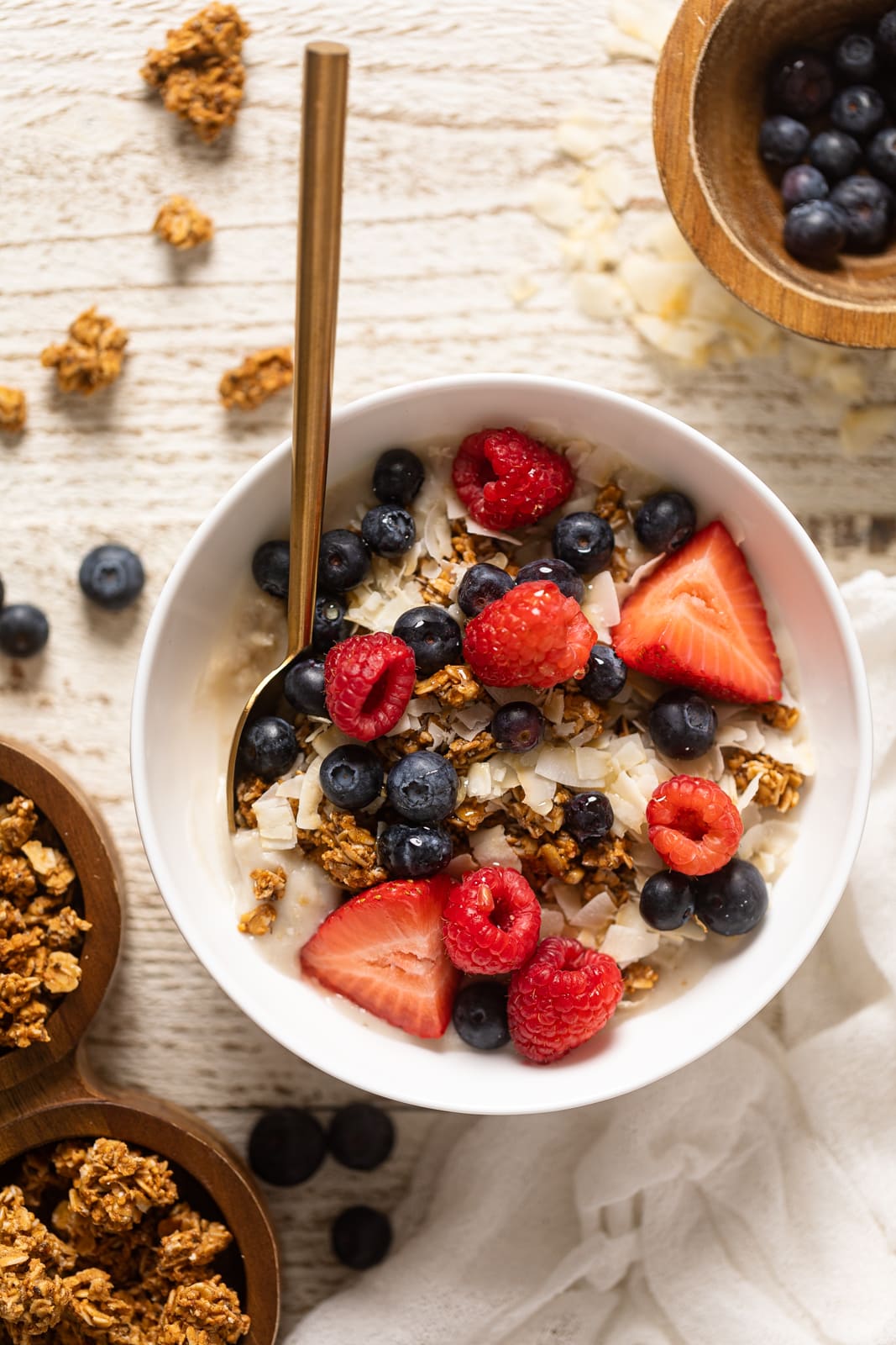 Overhead shot of a Coconut Berry Oatmeal Breakfast Bowl with a spoon a lots of berries