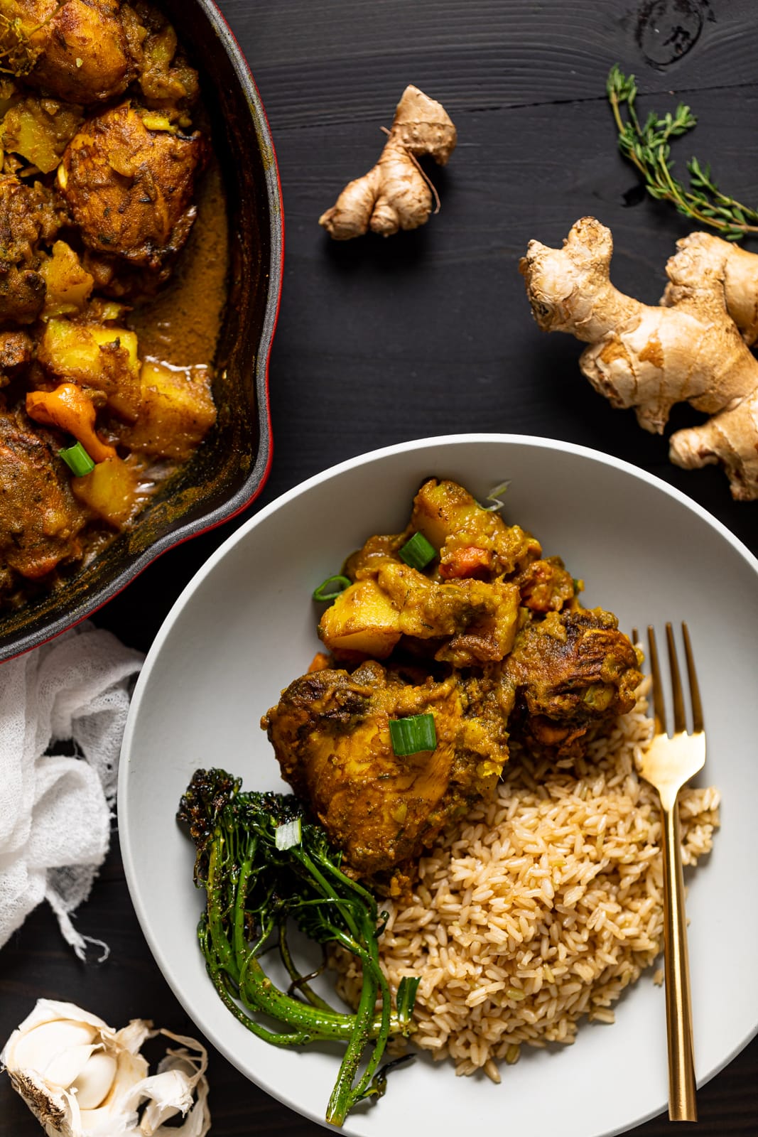 Plate of Jamaican Curry Chicken with rice and broccolini