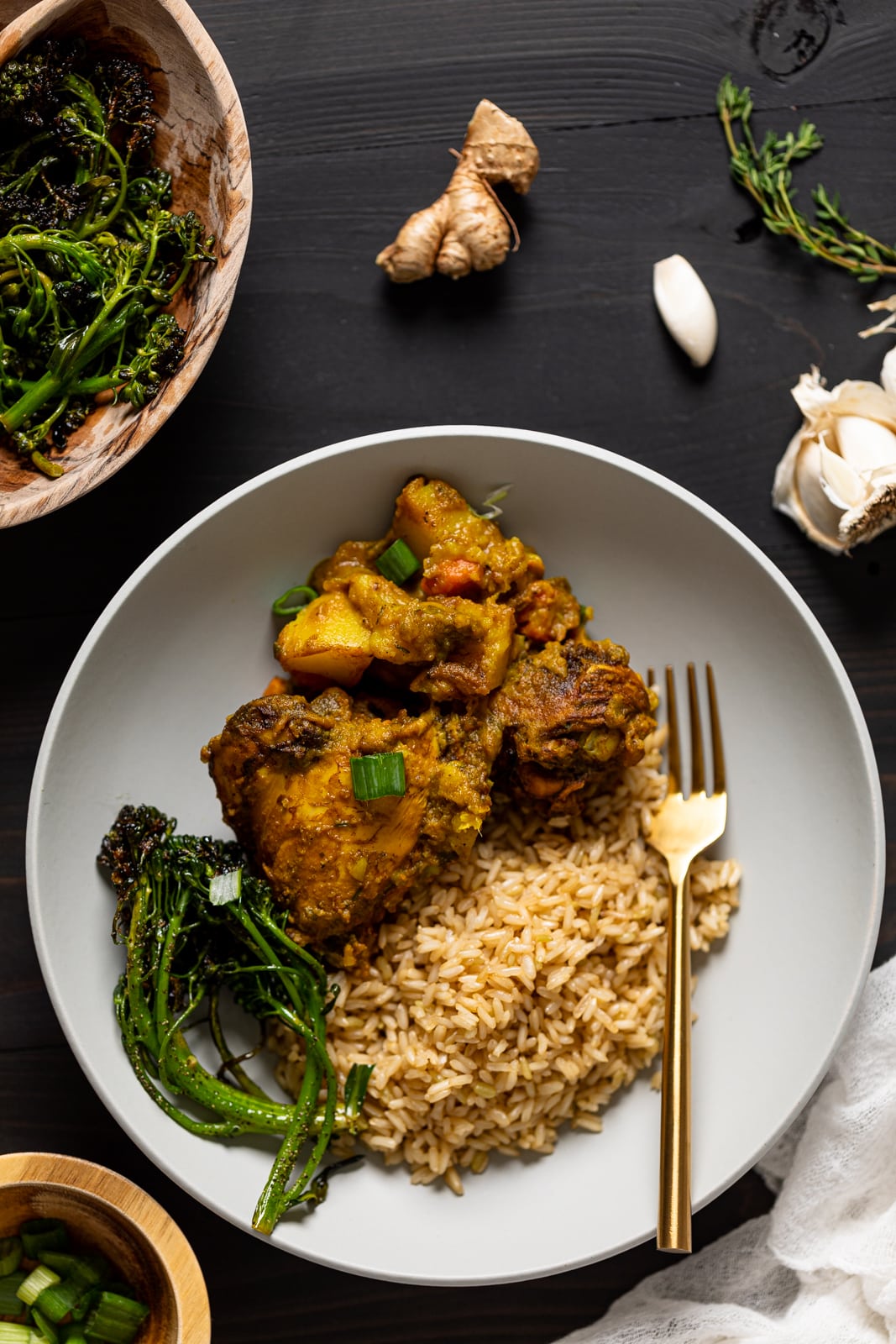 Plate of Jamaican Curry Chicken, rice, and broccolini