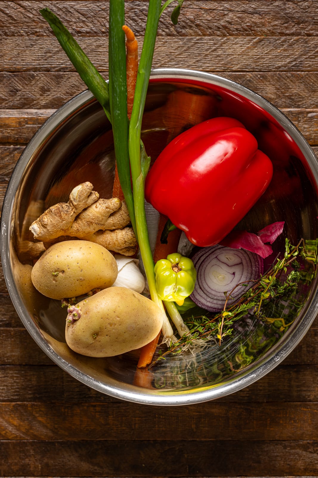 Ingredients in a silver bowl on a brown wood table.