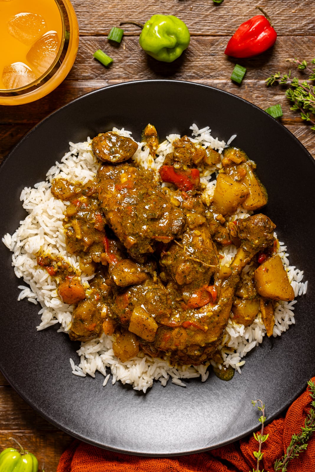 Curry chicken atop white rice in a black plate. 