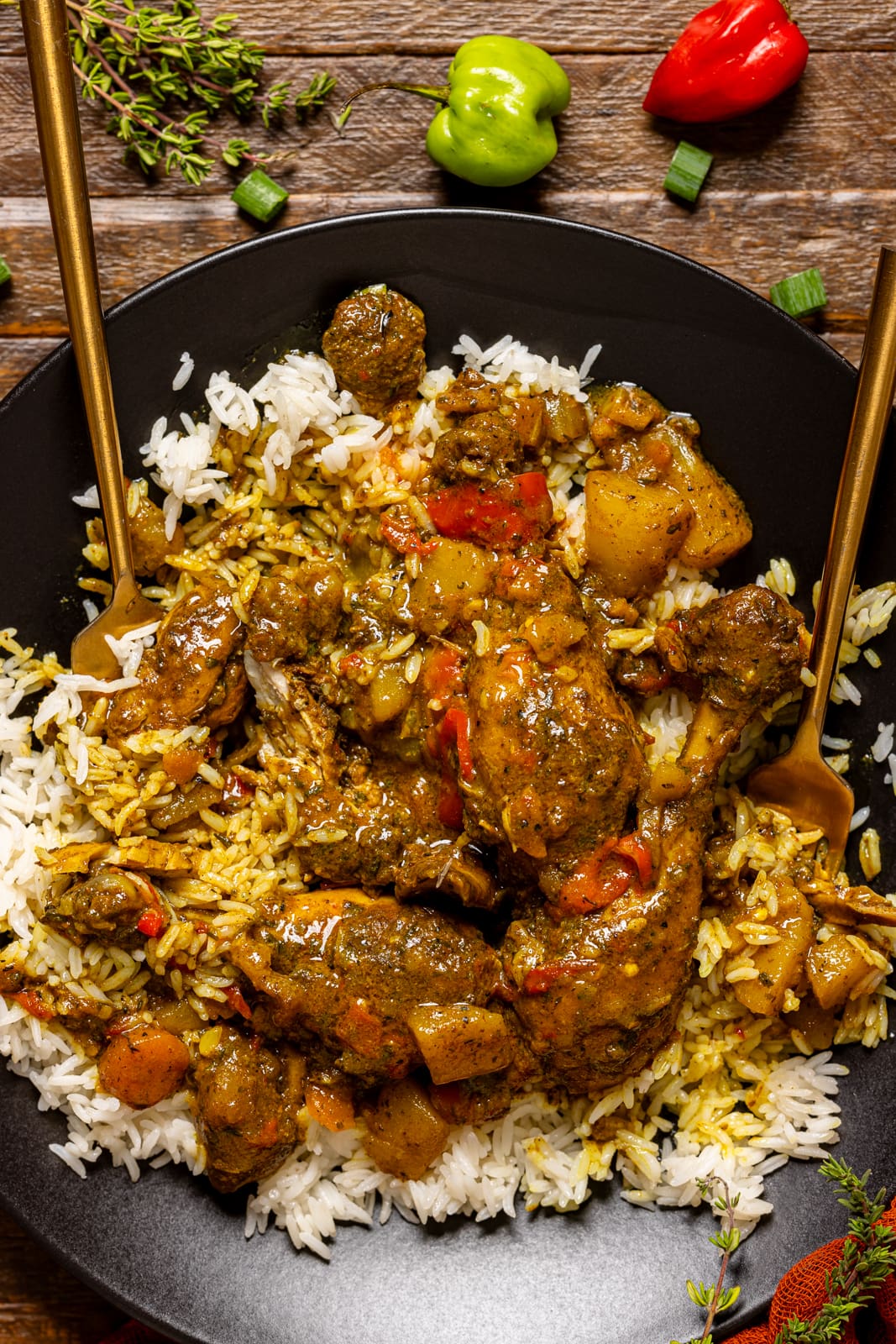 Curry chicken in a black plate with two forks.