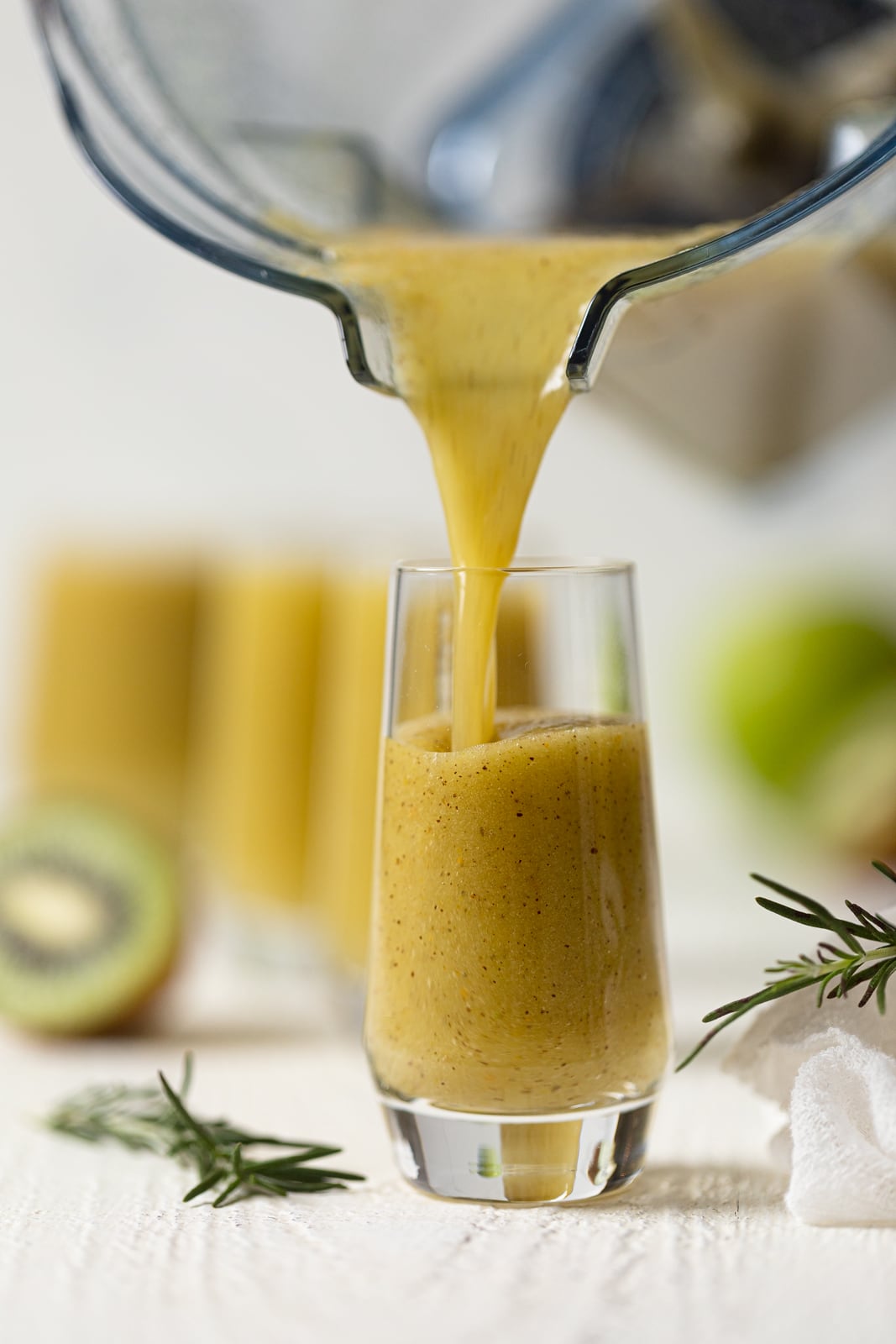 Cleansing Apple Kiwi Juice pouring from a blender into a glass