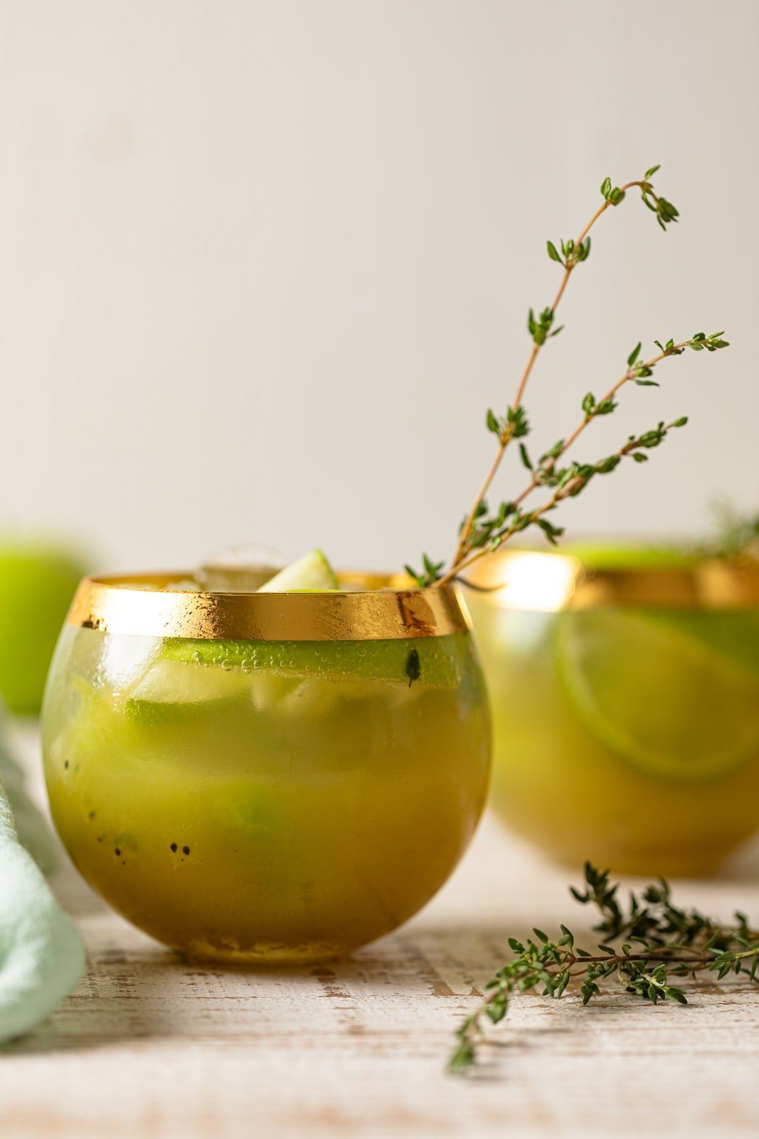 Two Green Goddess Mocktails in gold-rimmed glasses