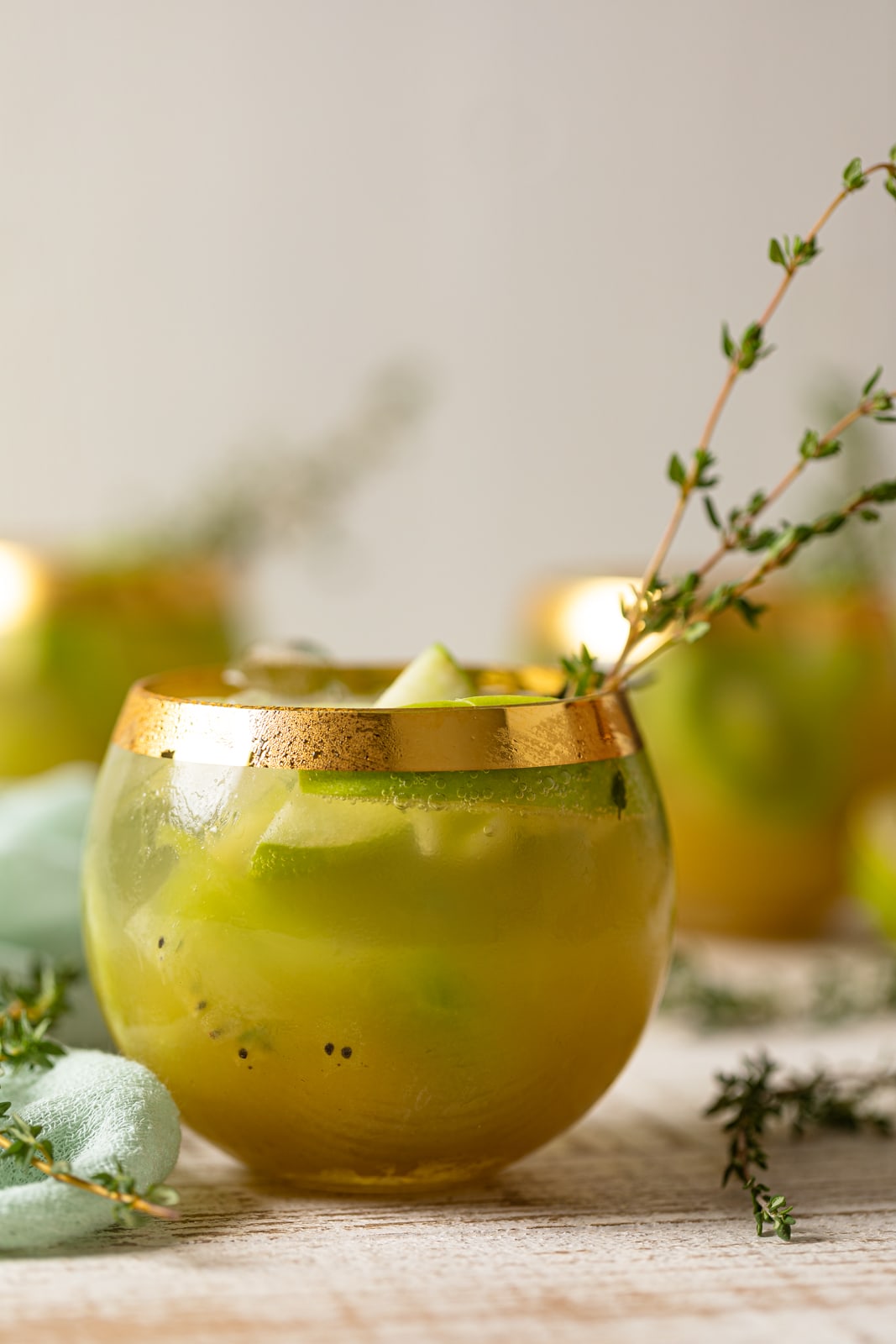Closeup of a Green Goddess Mocktail in a gold-rimmed glass