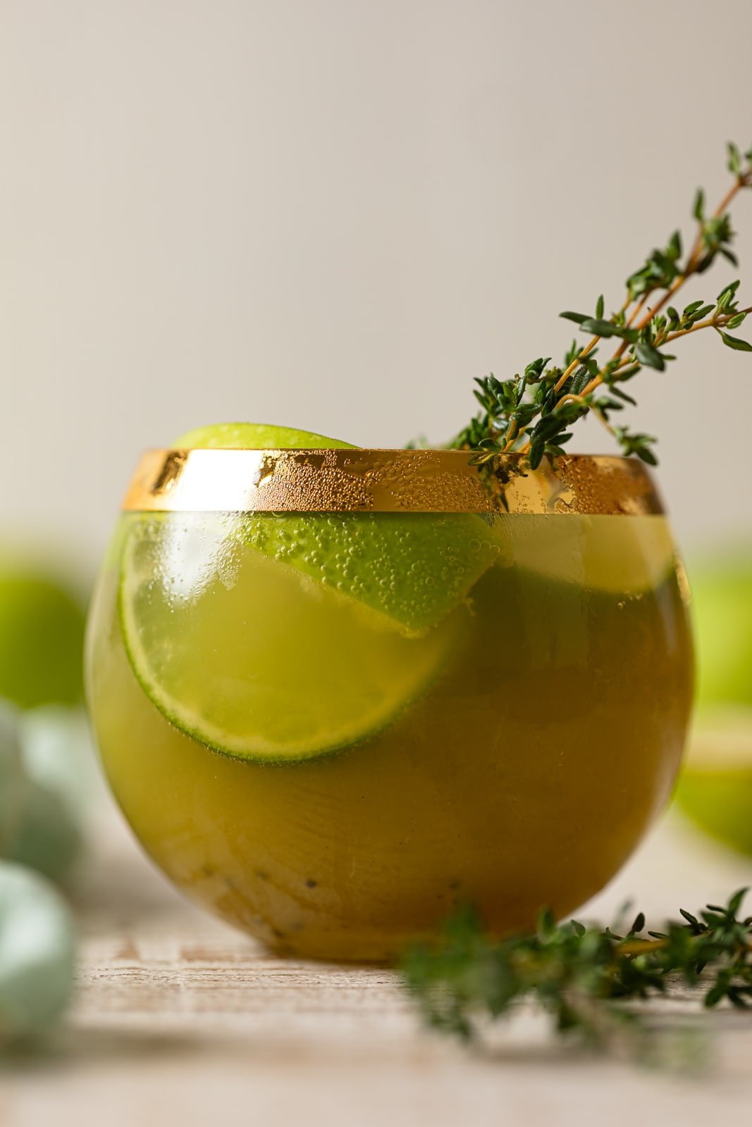 Closeup of a Green Goddess Mocktail in a gold-rimmed glass