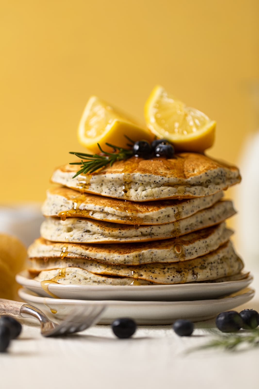 Stack of Vegan Lemon Poppyseed Pancakes on two stacked plates
