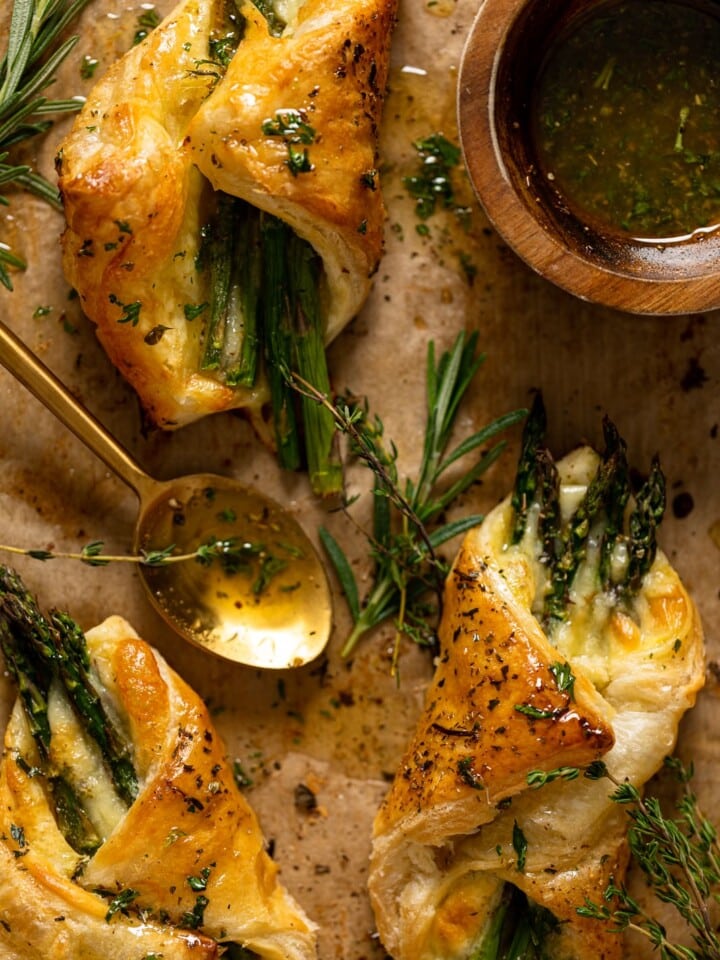 Asparagus and Mozzarella Puff Pastry with Herb Honey with a spoon on parchment paper