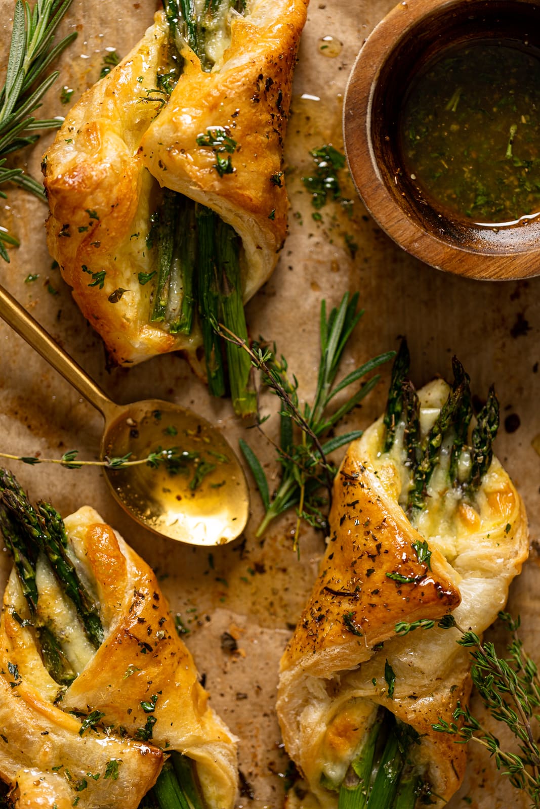 Asparagus and Mozzarella Puff Pastry with Herb Honey with a spoon on parchment paper