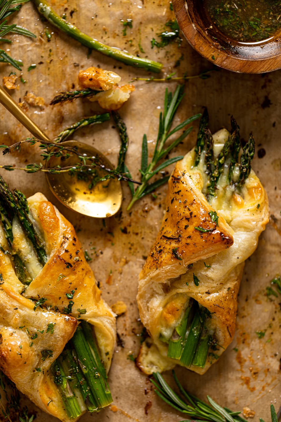 Closeup of Asparagus and Mozzarella Puff Pastry with Herb Honey with a spoon on parchment paper