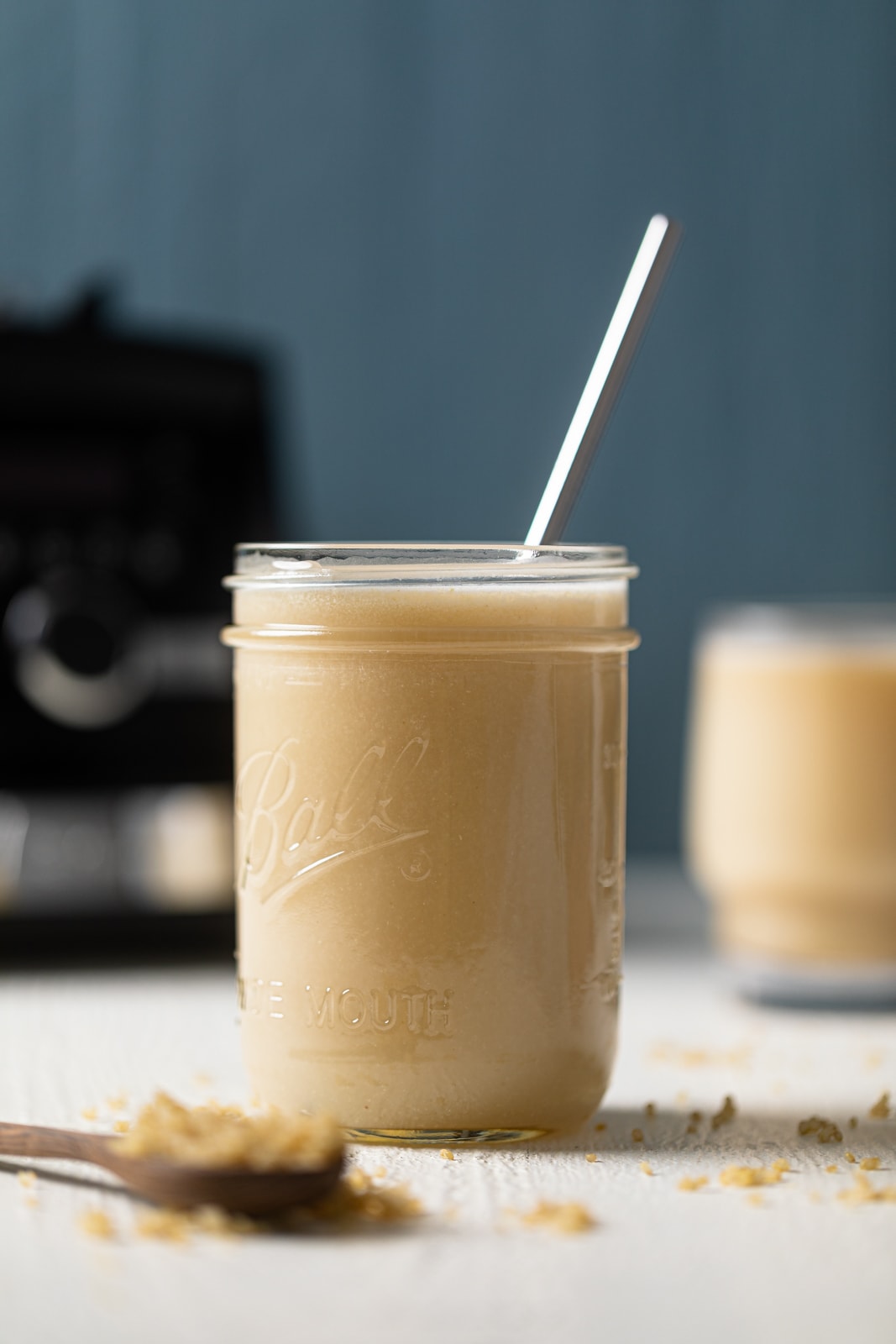 Canning jar of quinoa milk with a straw