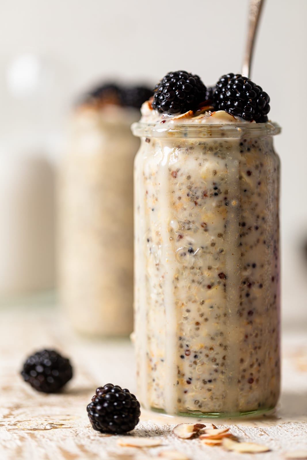 Closeup of a glass of Protein Overnight Quinoa topped with blackberries