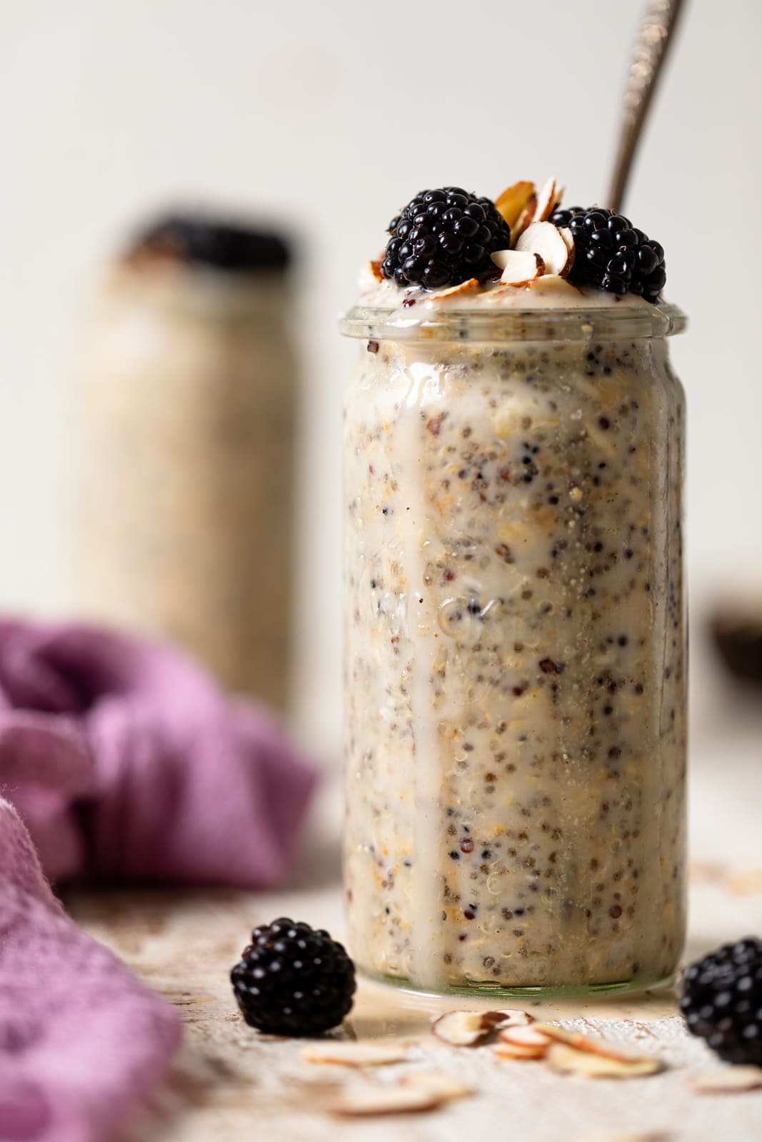 Closeup of a glass of Protein Overnight Quinoa topped with blackberries and slivered nuts