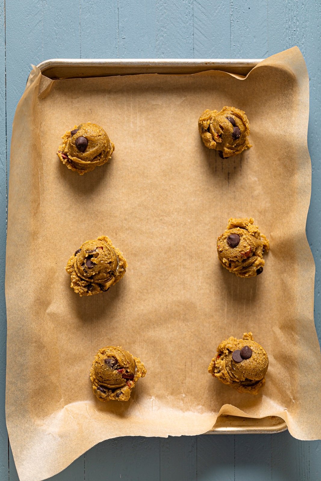 Balls of Espresso Rye Pecan Chocolate Chip Cookie dough on a baking sheet