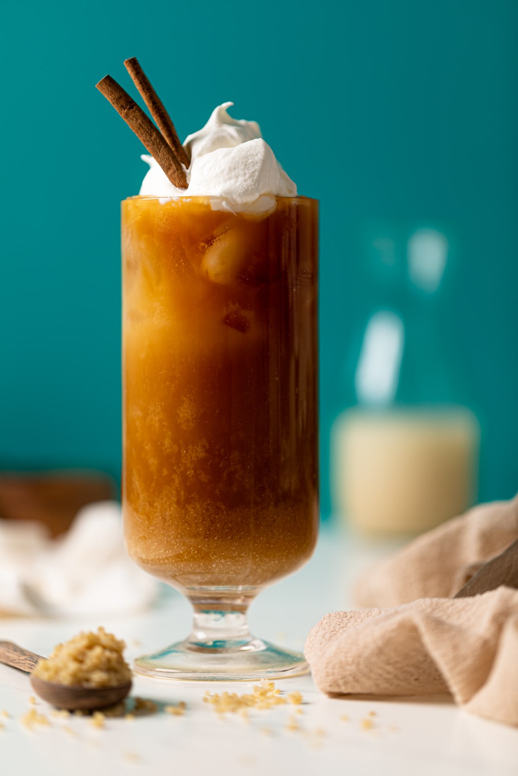 Iced Vanilla Latte with Quinoa Milk topped with coconut whipped cream and cinnamon sticks