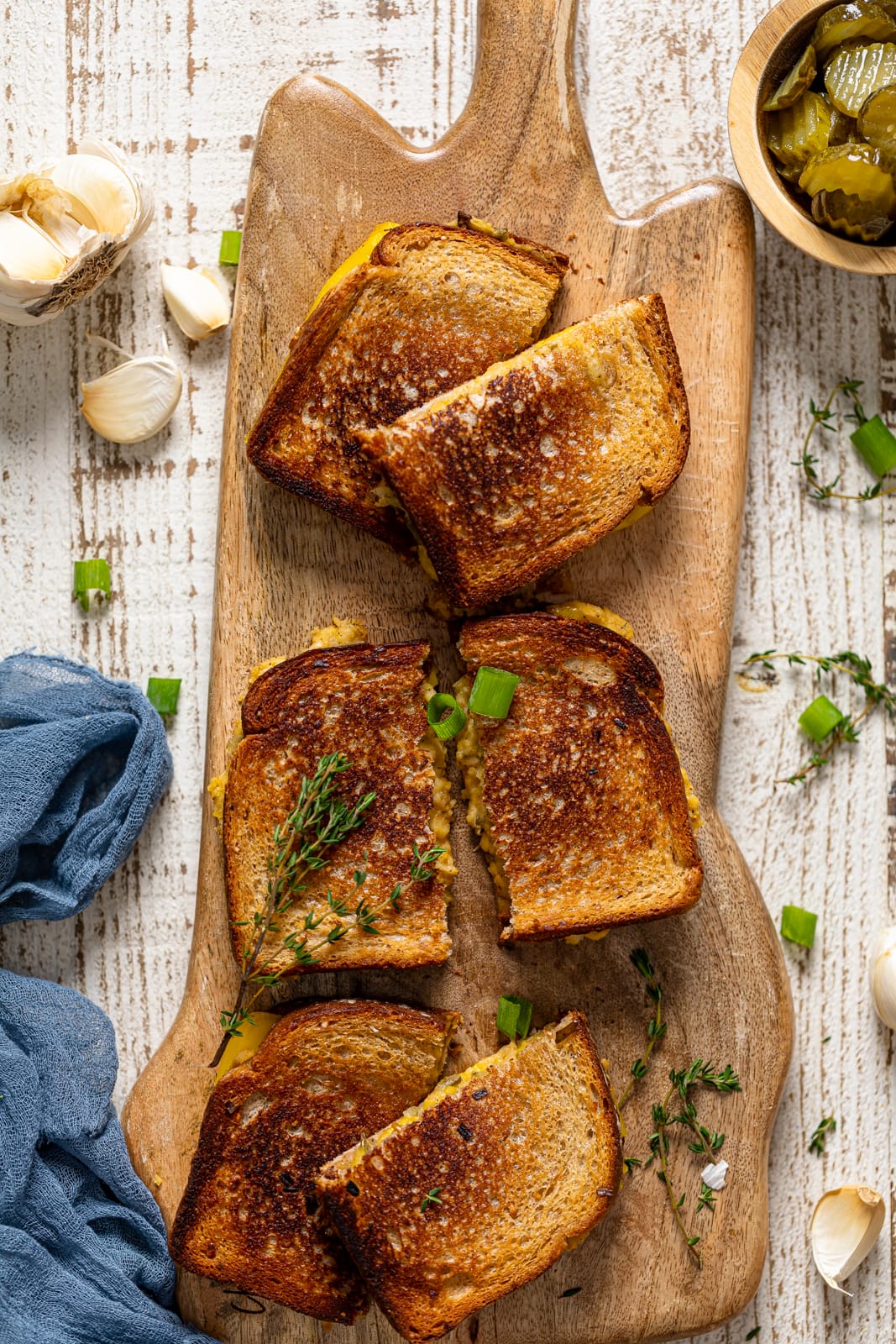 Three halved Vegan Chickpea Tuna Melt Sandwiches on a wooden board