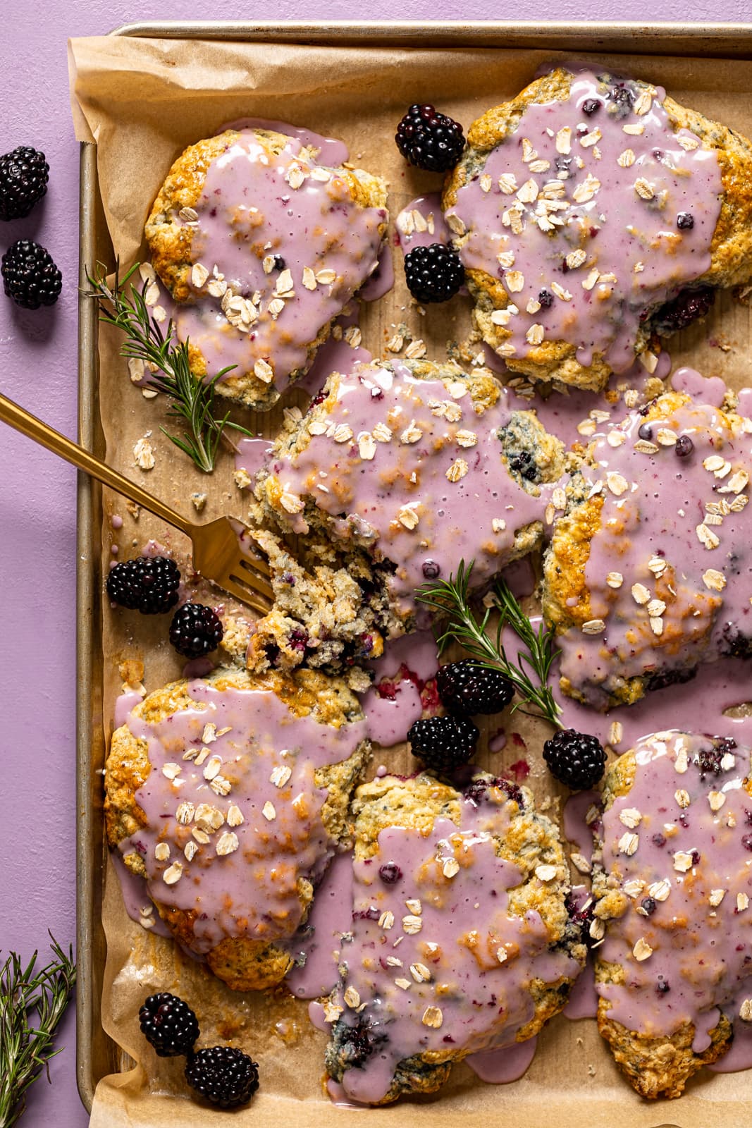 Sheet pan of Blackberry White Chocolate Oatmeal Scones with a fork