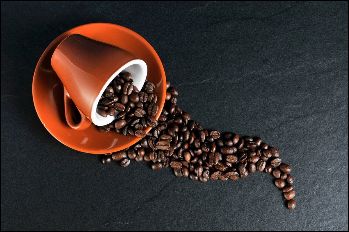 Cup and saucer spilling coffee beans