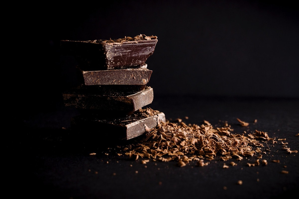 Pile of chocolate pieces next to chocolate shavings